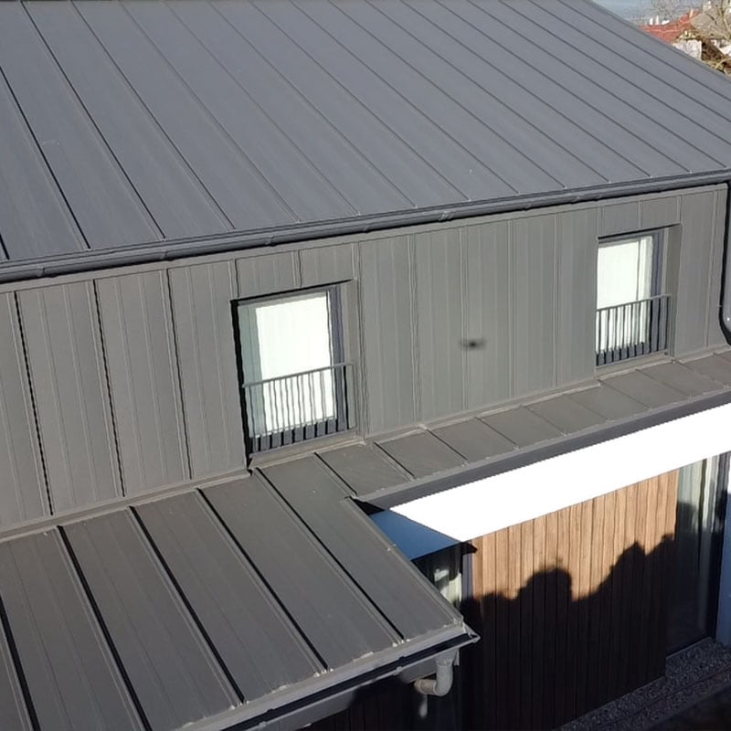 A képen egy korcolt lemezzel fedett modern családiház látható